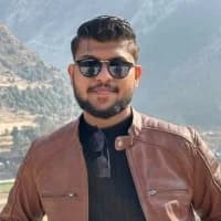 Photo of Syed Muhammad Ammar in sunglasses and a brown jacket with a scenic mountain backdrop.